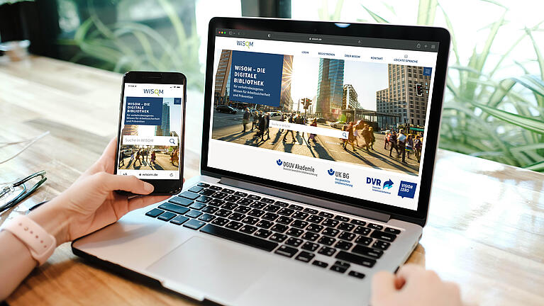 Blick auf einen geöffneten Laptop und ein Handy